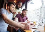 three guys look at a laptop